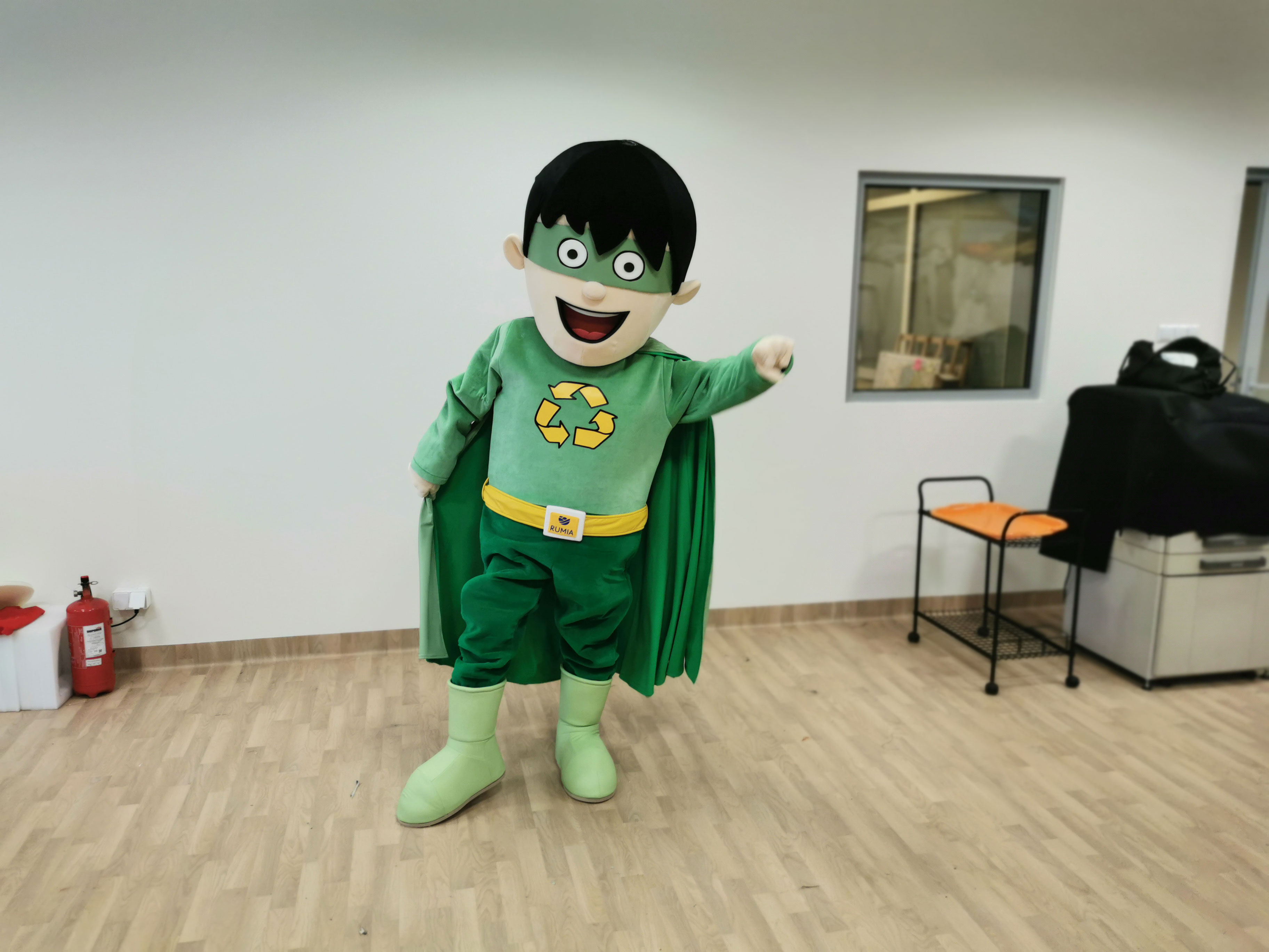 Na fotografii widnieje strój reklamowy w postaci chłopca pozujący do zdjęcia w siedzibie firmy Elabika
